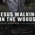 Man portraying Jesus walking peacefully through a wooded landscape in warm, cinematic lighting.