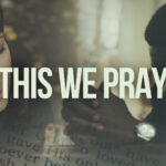 Mini-movie still from This We Pray showing believers united in prayer with atmospheric lighting and a message of hope.
