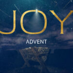 "Joy Advent" text in gold letters with star of Bethlehem shining above empty manger on deep blue starry night background for church advent video