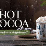 Cozy winter social media graphic featuring festive Christmas tree mug overflowing with hot cocoa topped with marshmallows and cinnamon sticks against snowy backdrop, asking "Hot Cocoa: marshmallows or whipped cream?" in elegant typography