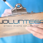 Woman wearing blue volunteer t-shirt holding clipboard, representing church volunteer opportunities and servant leadership