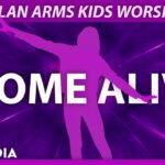 An energetic kids ministry worship video featuring a bright pink silhouette of a person standing with arms outstretched against a dark purple background with zooming light rays under the header "DYLAN ARMS KIDS WORSHIP".