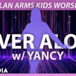 An energetic kids ministry graphic from the NEVER ALONE.jpg file featuring a purple silhouette of a person standing with arms outstretched against a dark purple background with cascading vertical light streaks and the text "NEVER ALONE w/ YANCY" under the header "DYLAN ARMS KIDS WORSHIP".